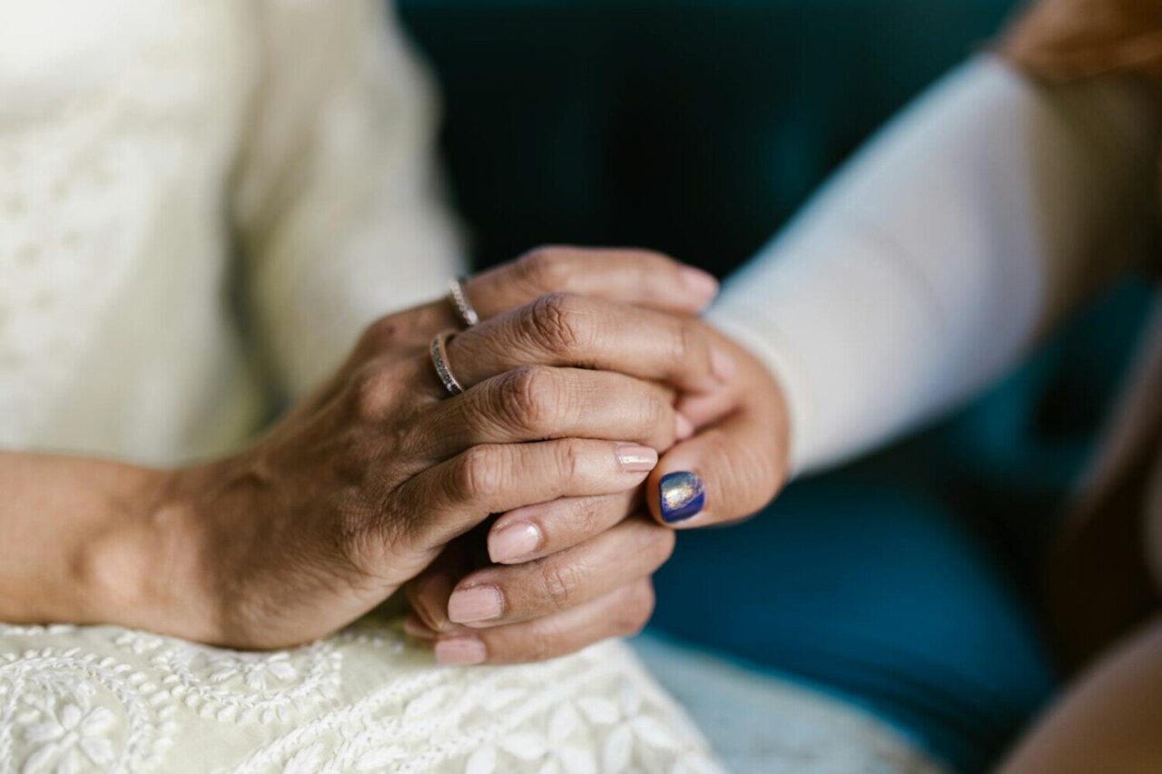A comforting close-up of two hands holding, showcasing support and unity.